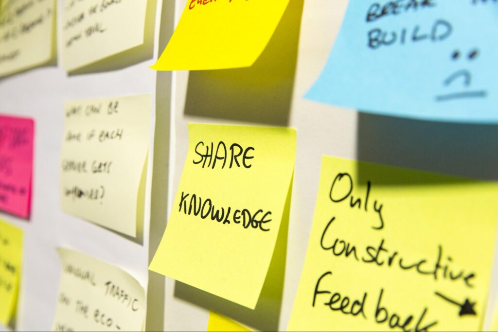 post-it notes on a wall saying 'share knowledge' and 'only constructive feedback'