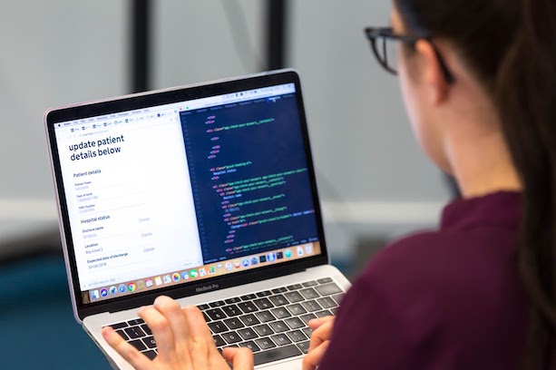 A person on a laptop with a screen showing a webpage and its code