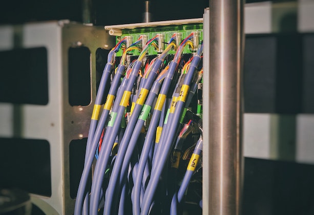 Purple cables with yellow and green markings plugged into networking equipment