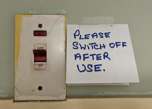 Photo of plug socket with post it saying 'Please switch off after use'
